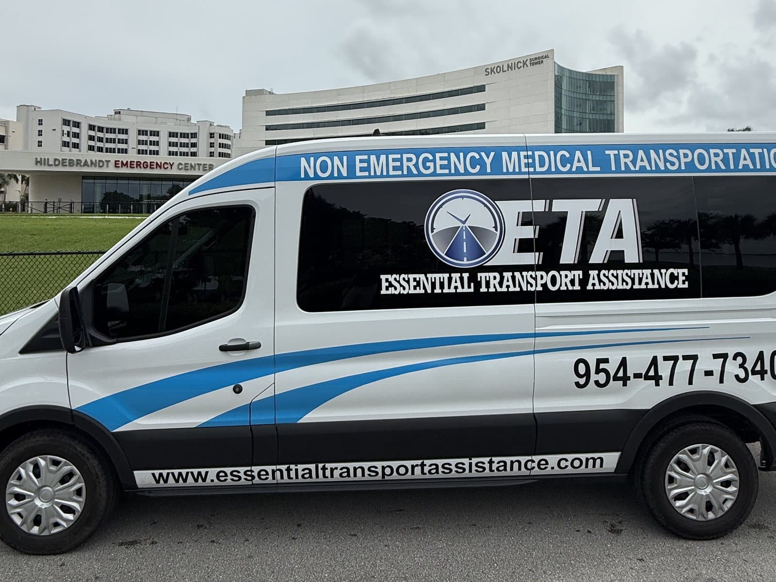 Essential Transport Assistance van outside Mount Sinai Medical Center in Miami Beach, with the Skolnick Surgical Tower behind it