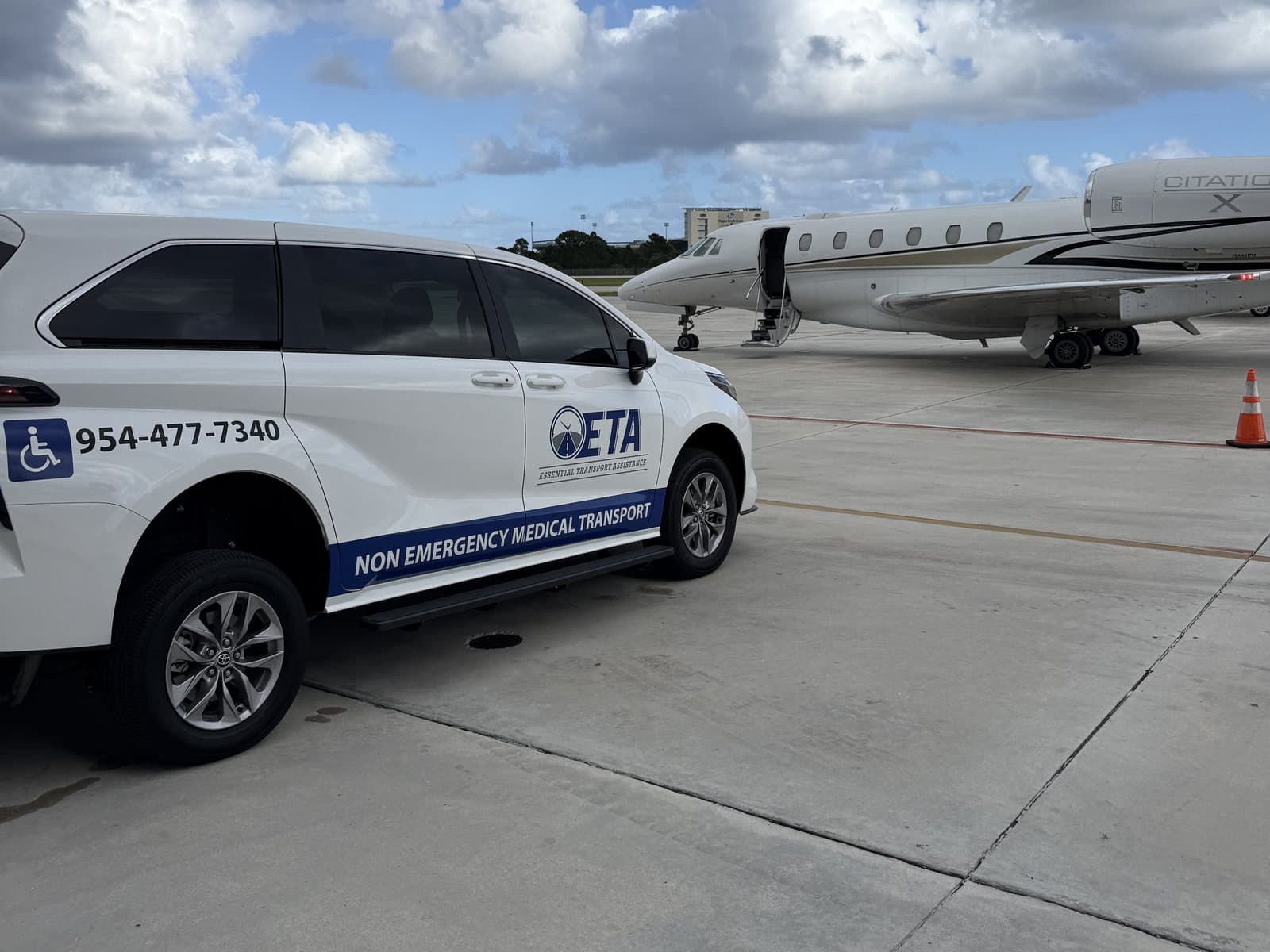 Essential Transport Assistance wheelchair-accessible minivan parked on the ramp beside a private jet at Boca Raton Airport