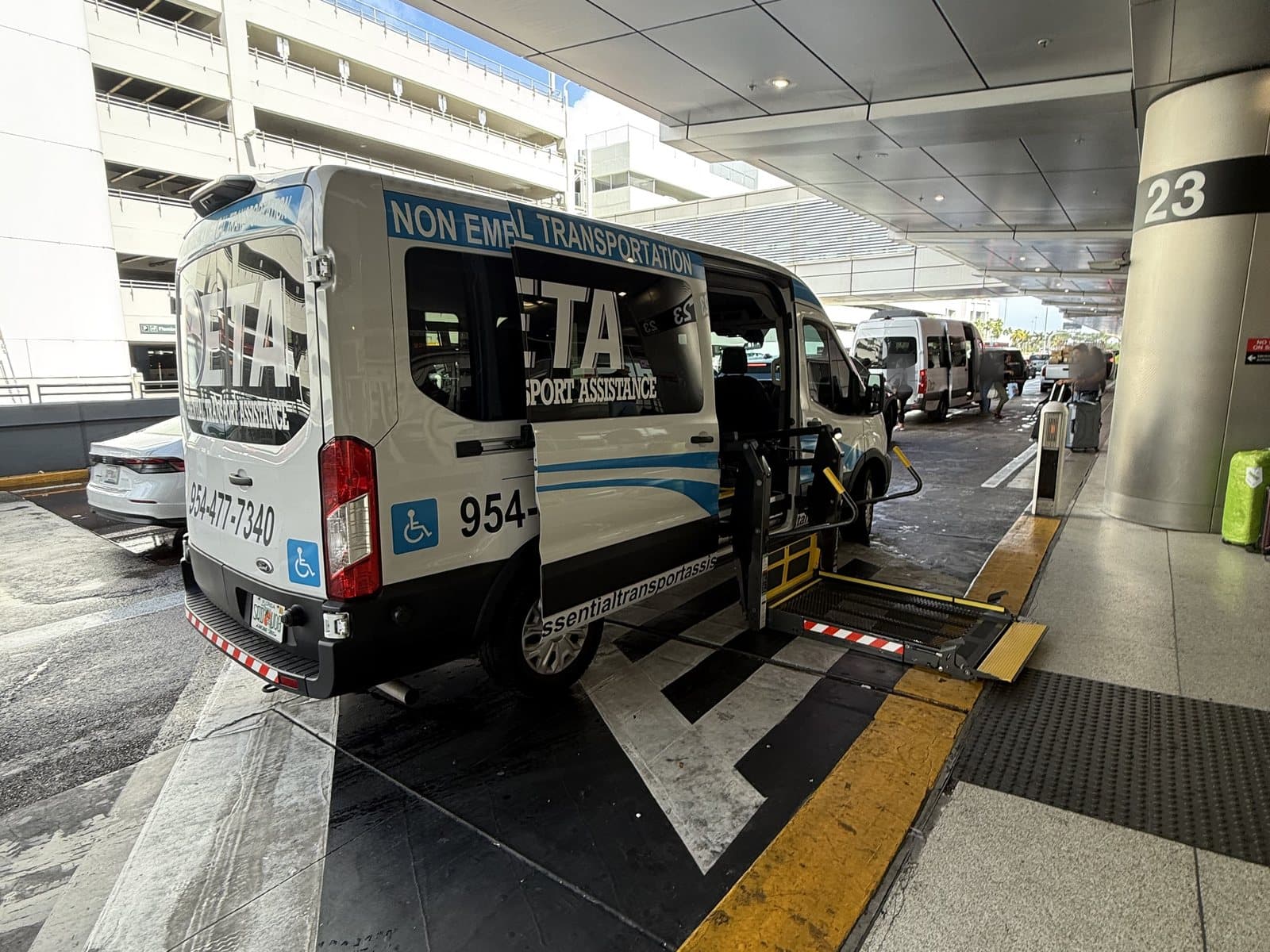 Essential Transport Assistance wheelchair-accessible minivan with its lift lowered at the Miami International Airport departures curb