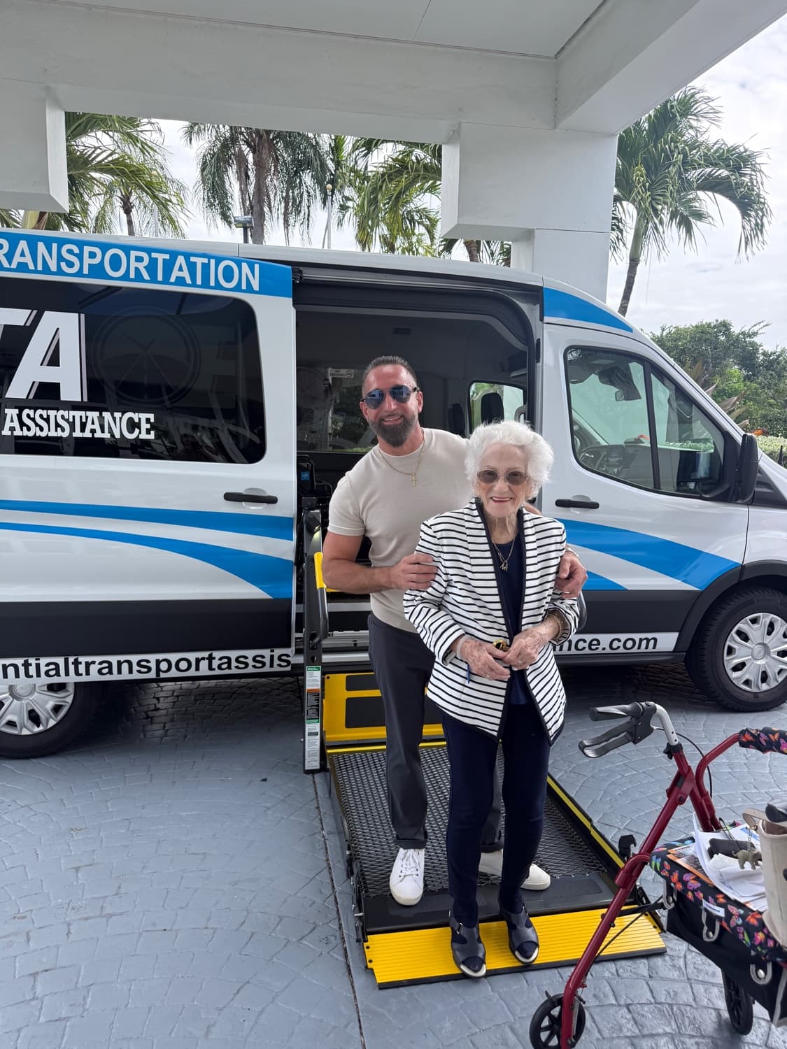 Essential Transport Assistance team member helping a passenger onto the wheelchair lift of the ETA medical transport van