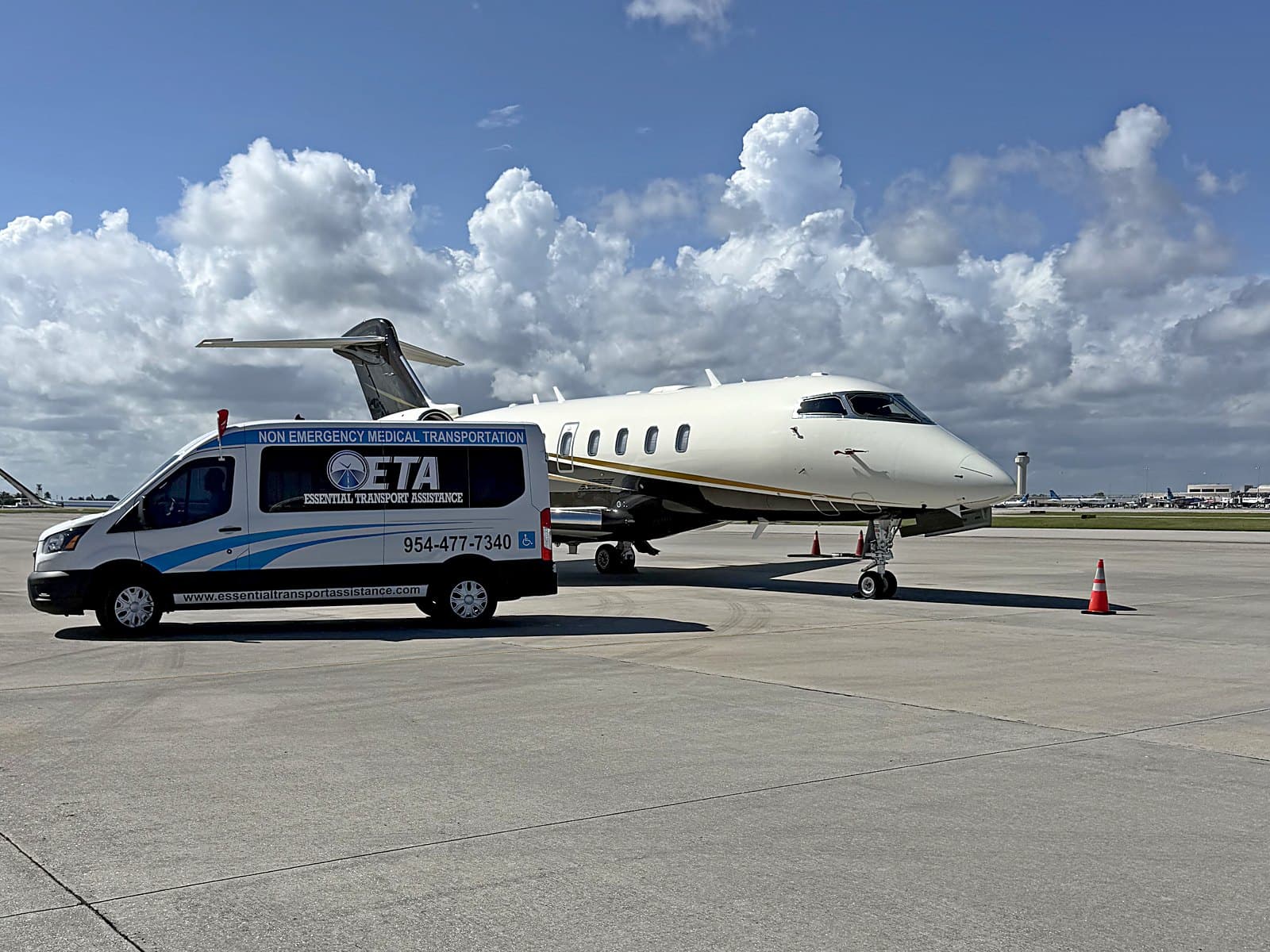 Essential Transport Assistance van parked beside a private jet on the ramp at Palm Beach International Airport